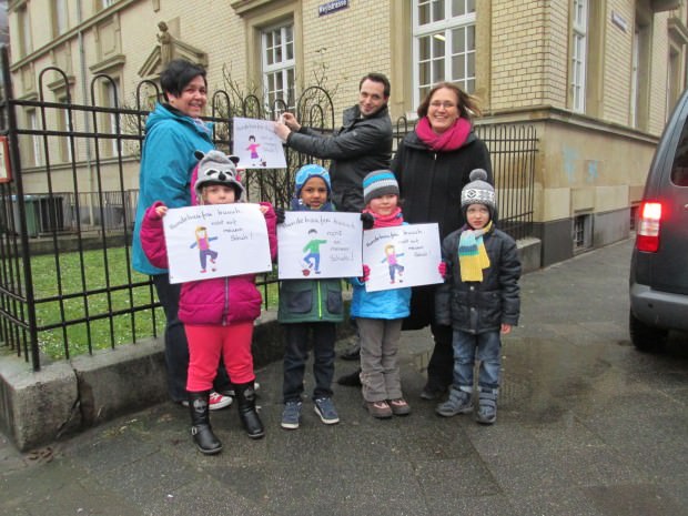 Trotz kühlem Nieselregen halten die Kinder entschlossen die selbstgemalten Schilder in die Kamera der Pressefotografen. Im Hintergrund: Kindergartenleiterin Martina Hartmann, Quartierbüroleiter Benjamin Klingler und Elternbeiratsprecherin Julia Stegmann (v.l.) | Foto: Neckarstadtblog