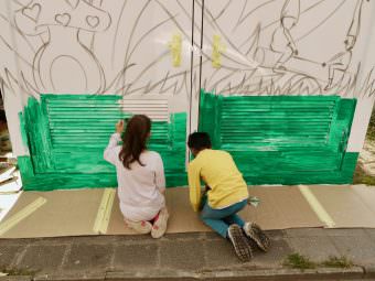 Fleißig malen die Kinder die Grundierung für die Grasfläche auf | Foto: M. Schülke