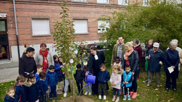 Die Evangelische Pfarrerin Judith Natho gießt das frisch gepflanzte Apfelbäumchen | Foto: M. Schülke