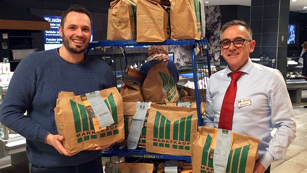 spende-quartierbuero-marktkauf-scheck-in-fb Marktleiter Harald Lammer (r.) übergibt die Tüten mit Lebensmitteln an Benjamin Klingler vom Quartierbüro Wohlgelegen | Foto: Caritas