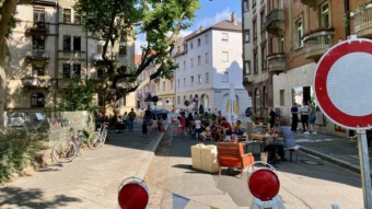 Am Clignetplatz wurde die Eichendorffstraße zwischen Spielplatz und Kleinem Café für Fußgänger*innen und Kinder geöffnet. Autos mussten draußen bleiben. Natürlich profitierte das Café davon, dass sich viele der verweilenden Menschen ein Eis, Kaffee und Kuchen holten, aber vor allem die Kinder des benachbarten Spielplatzes nutzten die Gelegenheit, so dass zeitweise alle Spielaktivitäten auf der Straße statt nebenan auf dem Spielplatz stattfanden | Foto: M. Schülke