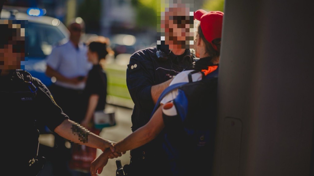 Gegenstand des Verfahrens: Dieses Foto des Polizeieinsatzes führte in seiner ursprünglichen, unverpixelten Form zur Anklage. (Gesicht und Namensschild durch die Redaktion anonymisiert) | Quelle: Archiv/X