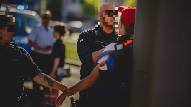 Gegenstand des Verfahrens: Dieses Foto des Polizeieinsatzes führte in seiner ursprünglichen, unverpixelten Form zur Anklage. (Gesicht und Namensschild durch die Redaktion anonymisiert) | Quelle: Archiv/X
